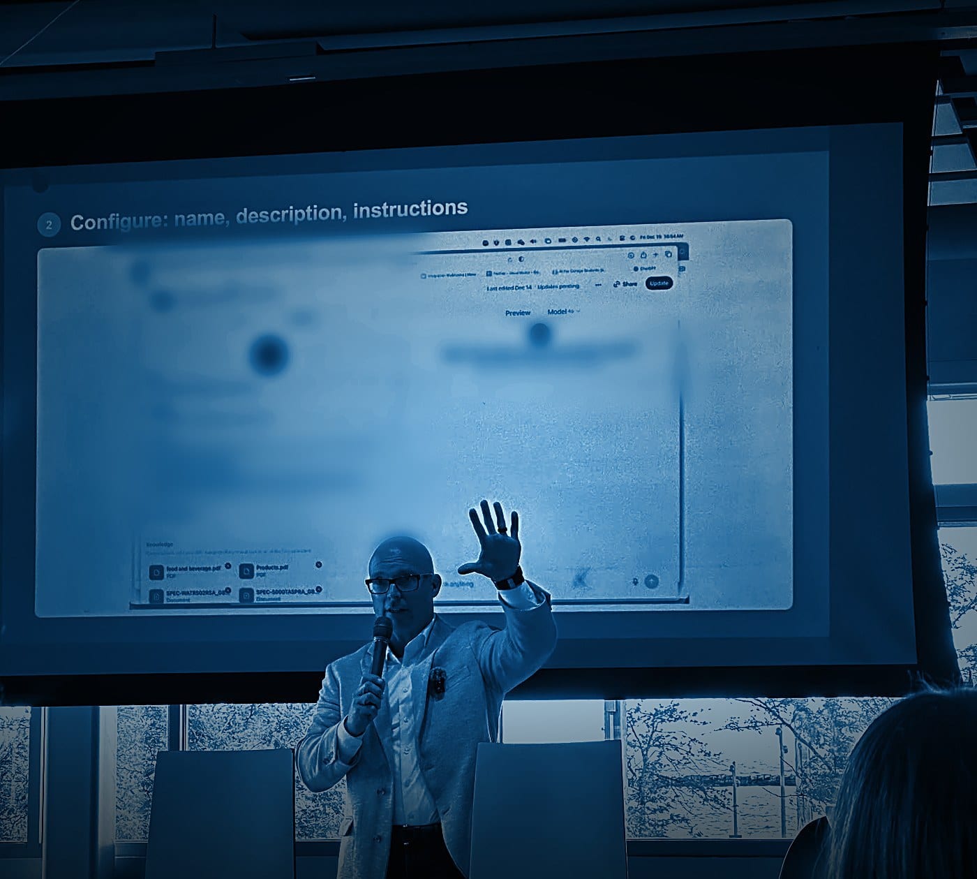 Chris Bernard building a custom AI assistant live on stage during a business AI session